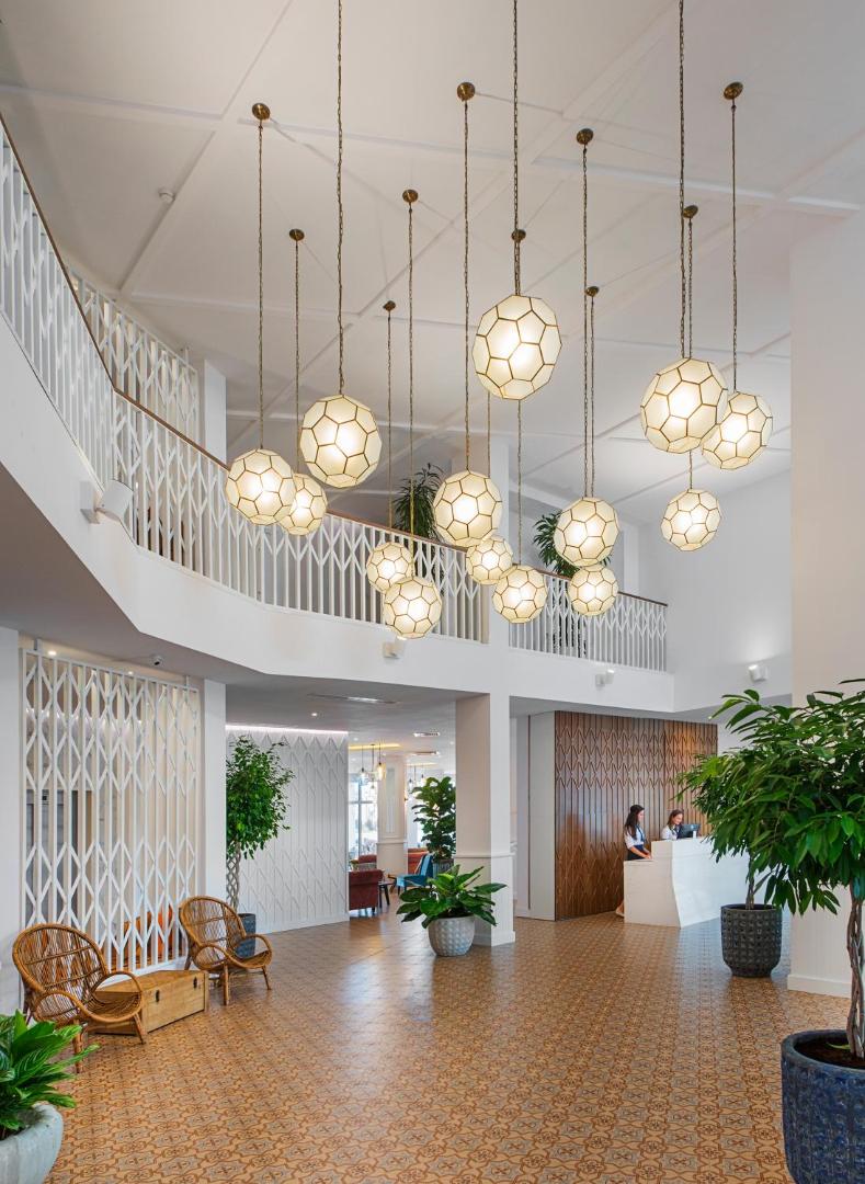 Sunrise Blue Magic Resort plašais vestibils ar augstiem griestiem, dizaina lampām un recepcijas zonu Obzorā