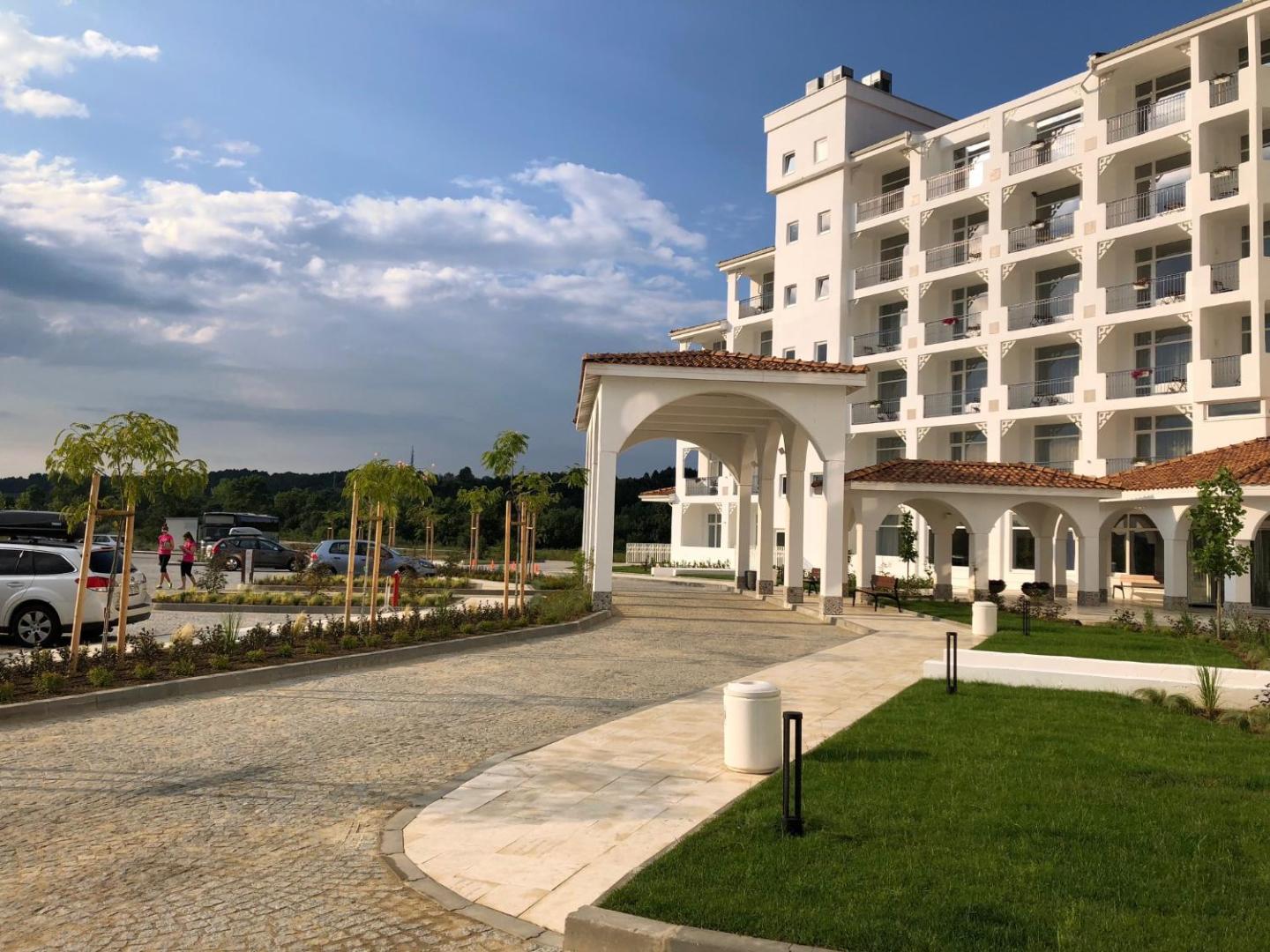 Sunrise Blue Magic Resort galvenā ieeja un piebraucamais ceļš ar modernu arhitektūru, koptu zālienu un dekoratīviem kokiem