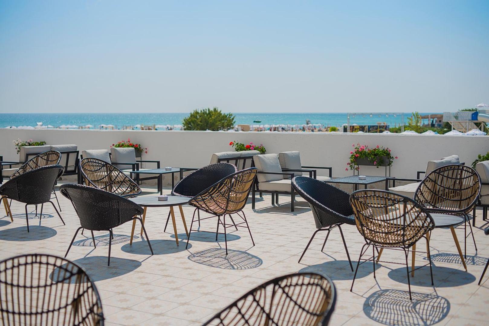 Sunrise Blue Magic Resort āra terase ar modernām pītām mēbelēm un skatu uz Melno jūru Obzorā — plaša atpūtas zona