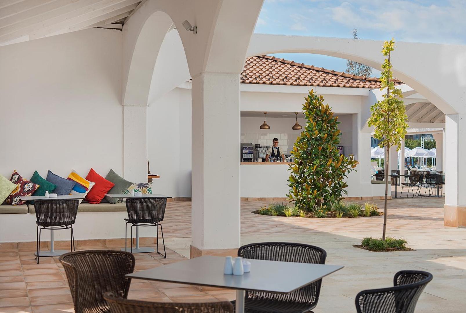 Viesnīcas Sunrise Blue Magic Resort bārs un atpūtas zona zem arkām — mīkstie dīvāni ar krāsainiem spilveniem un āra galdiņi