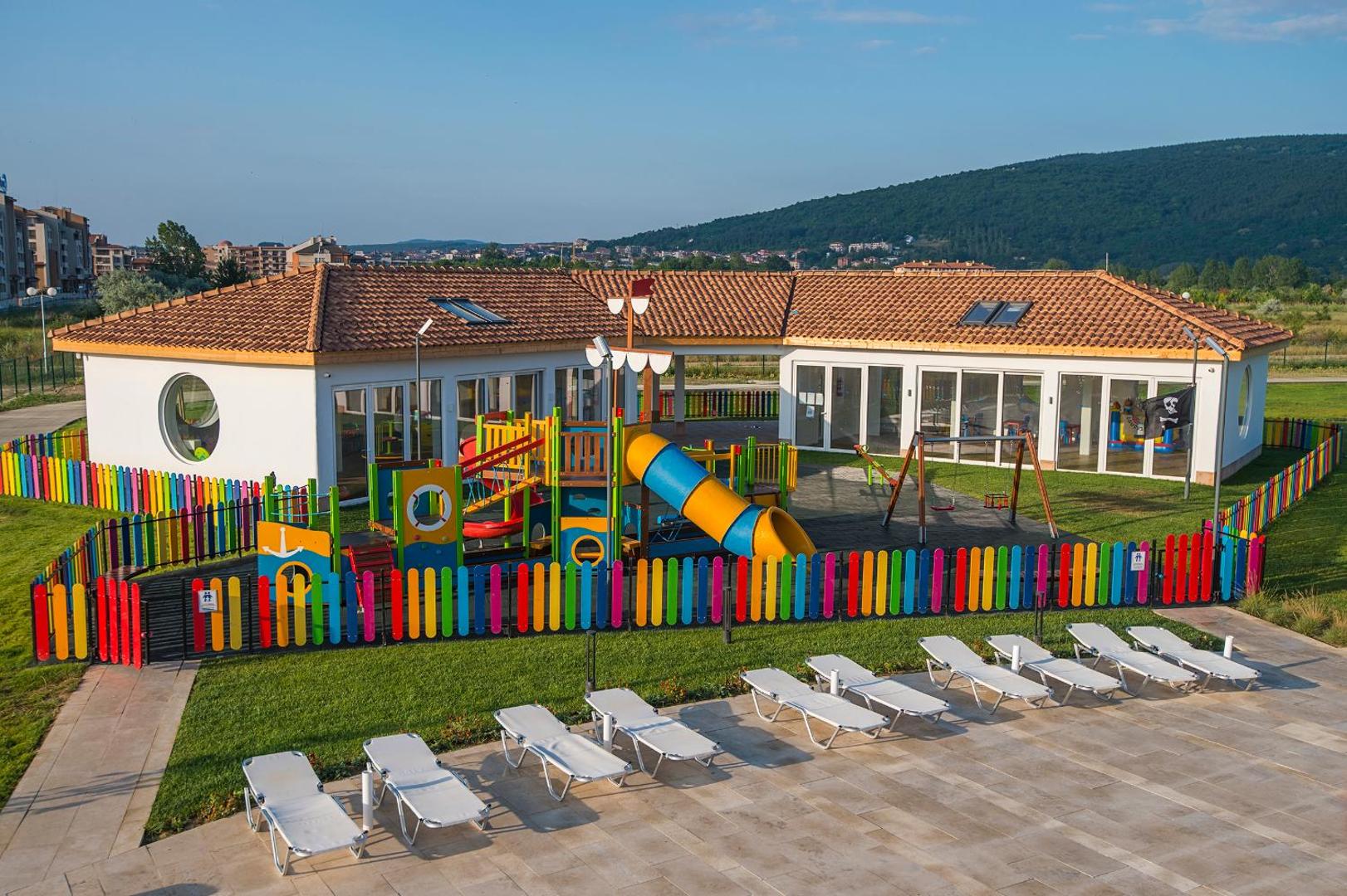 Sunrise Blue Magic Resort bērnu klubs un rotaļu laukums ar slidkalniņiem un šūpolēm — droša, iežogota teritorija blakus sauļošanās zonai