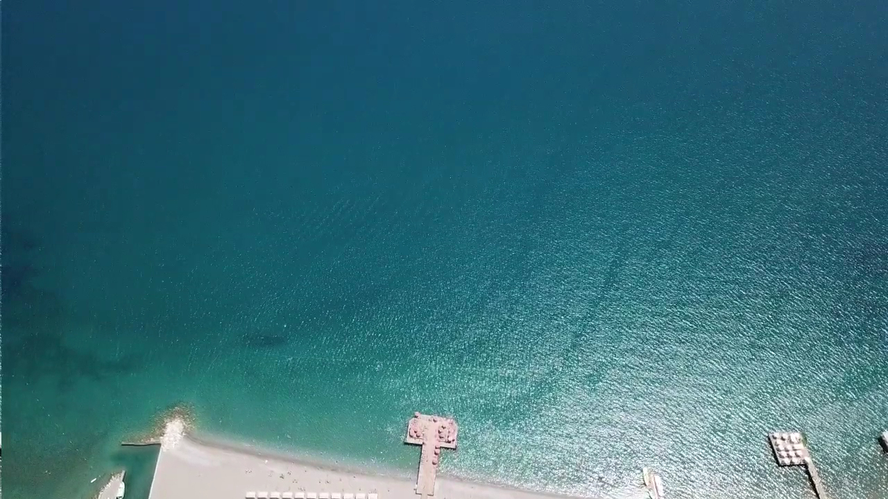 Aerofoto skats uz Akka Antedon pludmales zonu un dzidro Vidusjūras ūdeni Beldibi — koka laipa un tirkīzzils ūdens no putna lidojuma