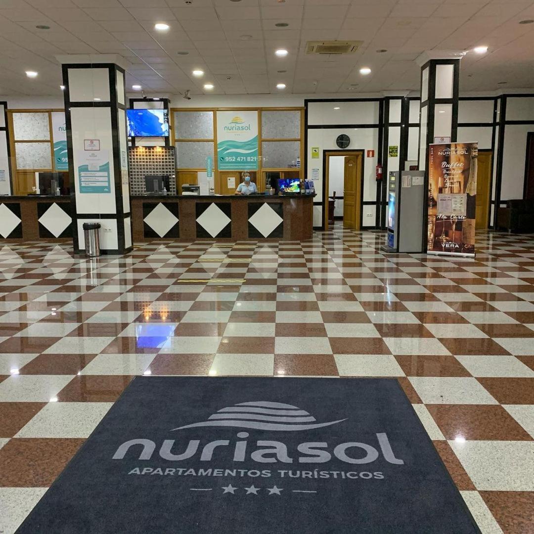 Apartamentos Nuria Sol 3* viesnīcas recepcijas zona ar rūtainu marmora grīdu un reģistrācijas leti Fuengirolā