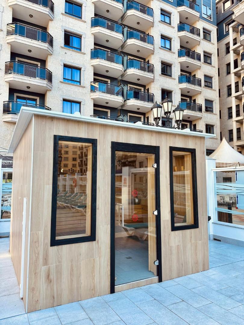 Apartamentos Nuria Sol āra sauna uz terases pie baseina zonas ar skatu uz daudzstāvu apartamentu ēku Fuengirolā