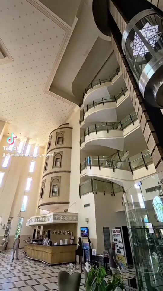 Mukarnas Spa & Resort viesnīcas vestibils ar augstiem griestiem, modernu liftu un recepcijas zonu Alānijas reģionā, Turcijā