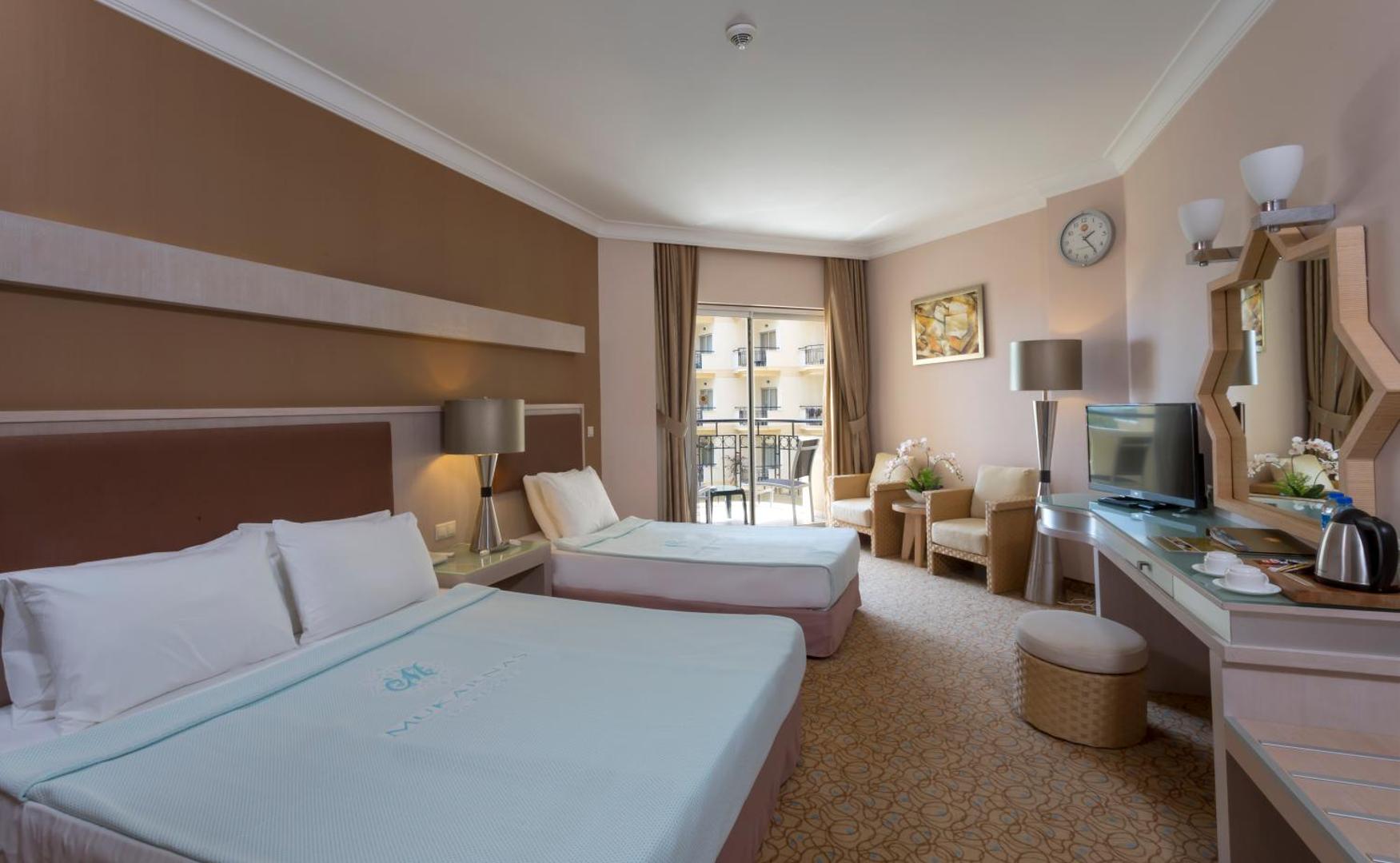 Mukarnas Spa & Resort gaišs numurs ar divām gultām, atpūtas zonu, spoguli un balkonu, kas vērsts pret viesnīcas teritoriju