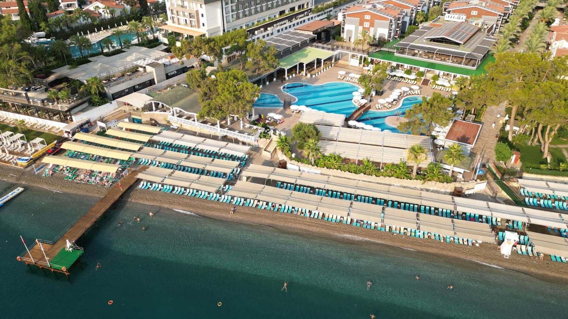 Crystal Aura Beach Resort & Spa panorāmas skats no augšas uz baseiniem un privāto pludmali Kemeras piekrastē Turcijā