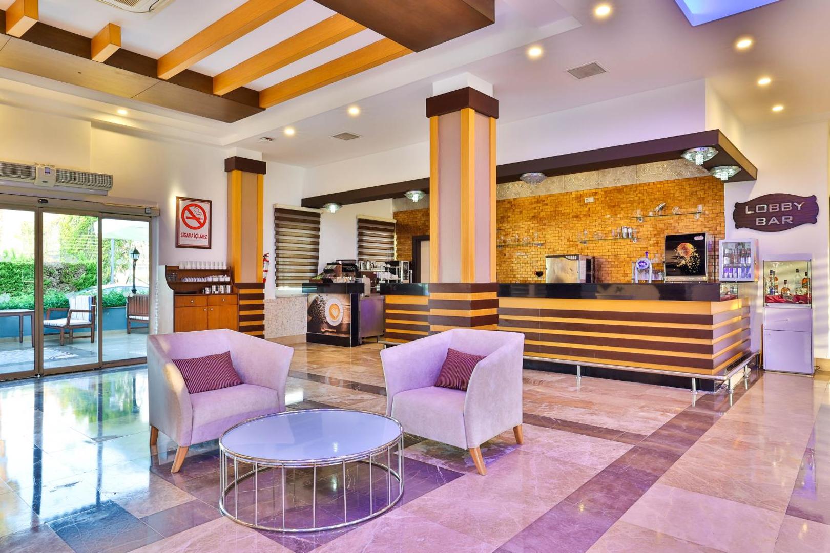 Crystal Aura Beach Resort & Spa viesnīcas lobby bārs ar gaišiem atpūtas krēsliem, modernu interjeru un kafijas stūrīti Kemeras reģionā
