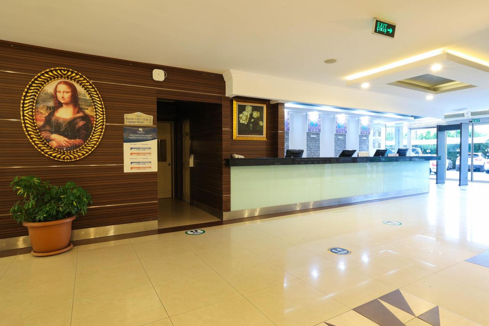 Crystal Aura Beach Resort & Spa viesnīcas lobby zona ar recepcijas leti un Monas Lizas gleznas reprodukciju pie sienas