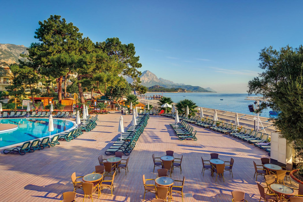 Crystal Aura Beach Resort & Spa āra baseins un sauļošanās terase Vidusjūras piekrastē ar skatu uz kalniem un pludmali