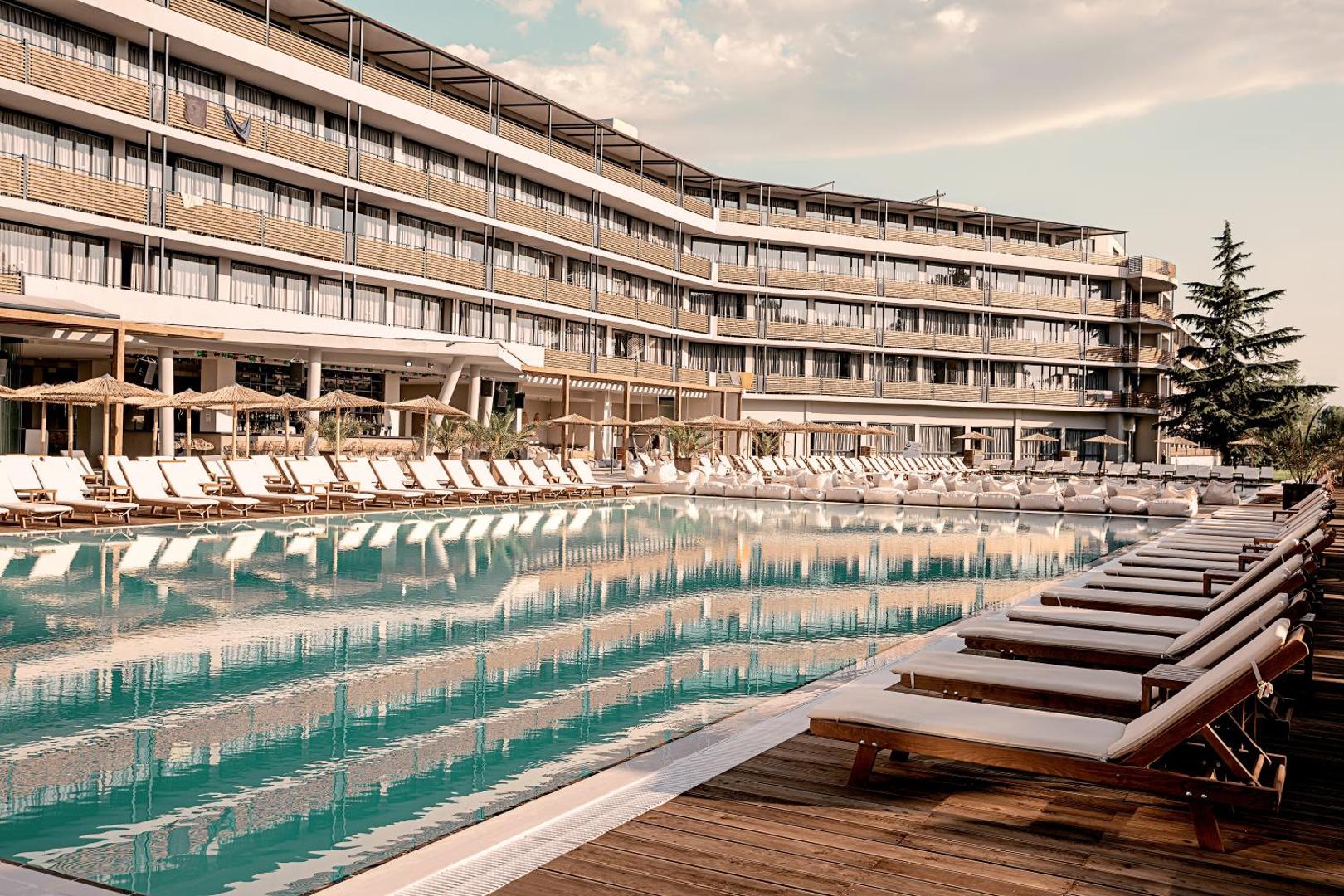 Sunny Beach Club viesnīcas eksterjers ar lielu āra baseinu, sauļošanās krēsliem un koka klāju Saulainajā Krastā, Bulgārijā.
