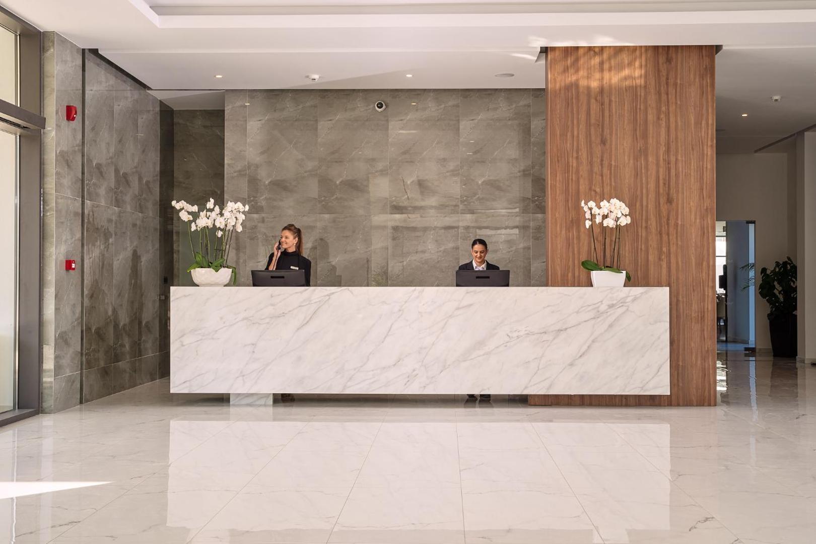 Lindos Grand Resort & Spa modernā recepcijas zona ar marmora apdari un viesmīlīgu personālu Rodas salā