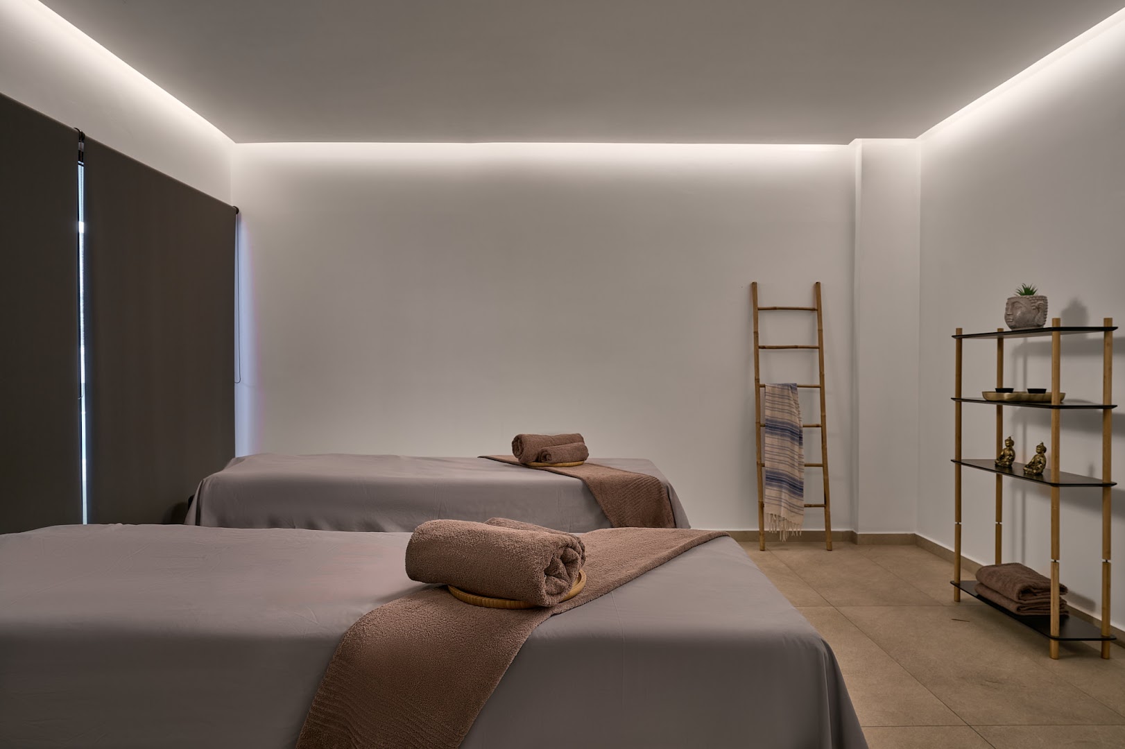 Lindos Grand Resort & Spa spa procedūru telpa ar divām kušetēm, mierīgu apgaismojumu un minimālistisku dizainu relaksējošai atpūtai