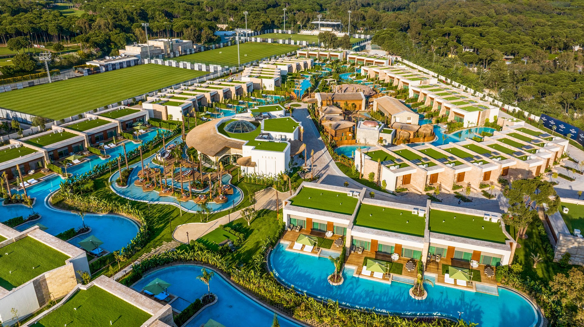 Regnum Carya luksusa bungalo komplekss no putna lidojuma ar privātiem baseiniem un futbola laukumiem fonā Belekas reģionā