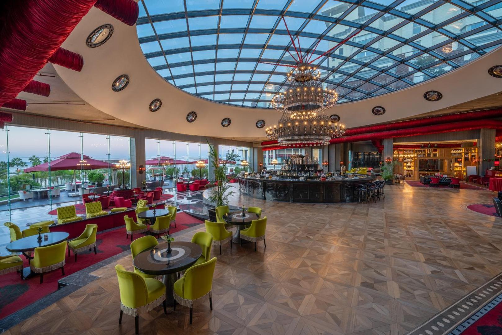 Selectum Luxury Resort iespaidīgais lobby bārs ar milzīgu stikla kupolu, greznu lustru un krāsainām atpūtas mēbelēm