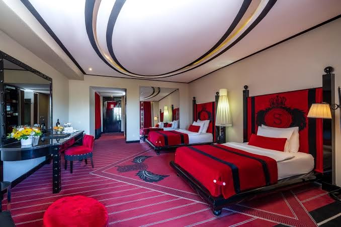 Selectum Luxury Resort numurs ar divām atsevišķām gultām, sarkanu interjeru, rakstāmgaldu un dekoratīviem sienas elementiem.