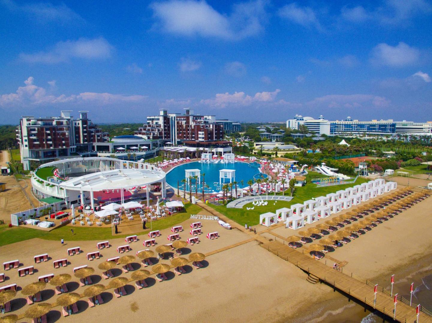 Selectum Luxury Resort privātā pludmale ar saulessargiem un skatu uz centrālo baseinu un viesnīcas kompleksu Belekā