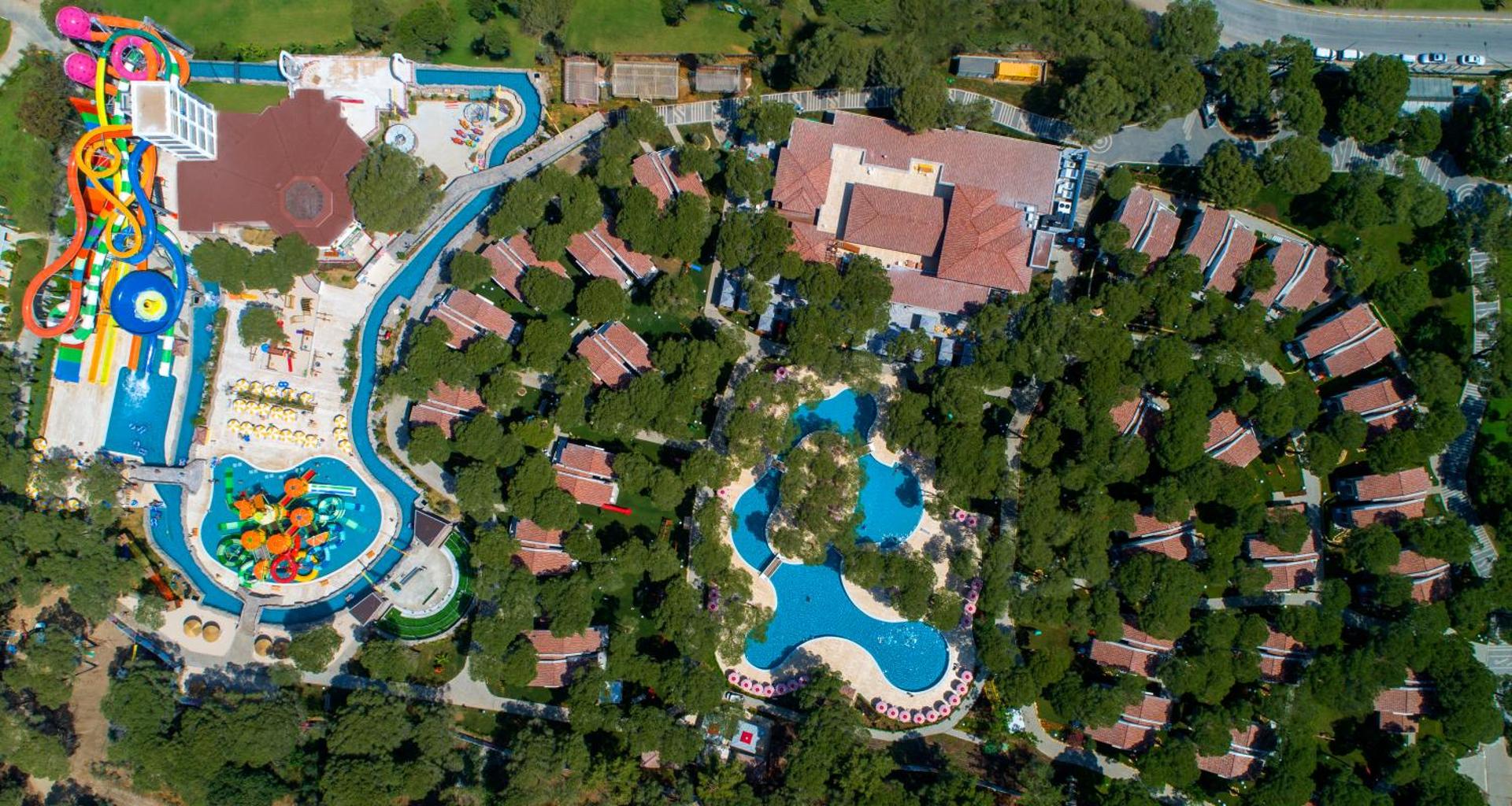 Selectum Luxury Resort akvaparks un bungalo ciemats no augšas — krāsaini slidkalniņi un baseini priežu meža ielokā