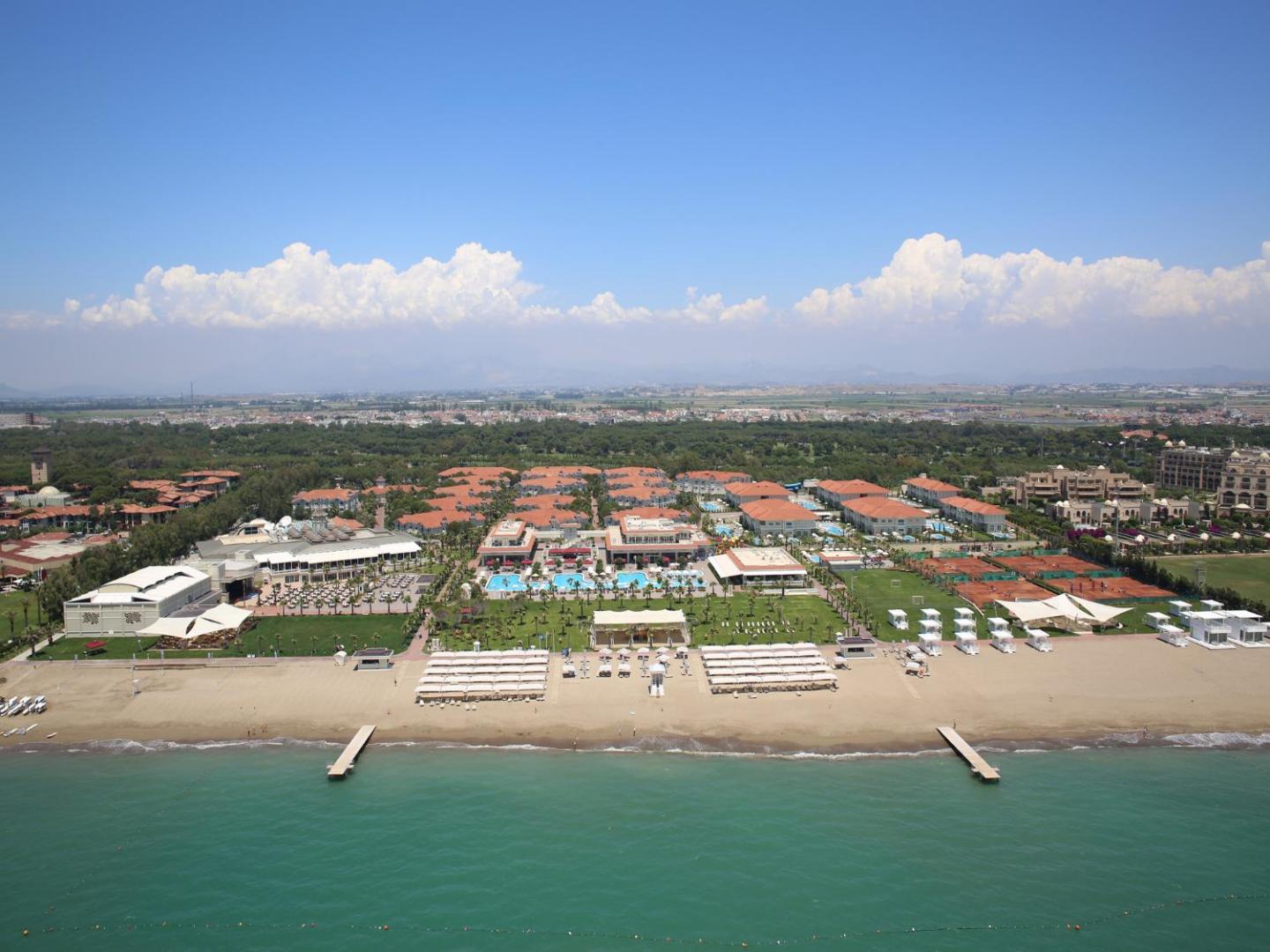 Gural Premier Belek panorāmas skats uz privāto pludmali, tenisa kortiem un viesnīcas kompleksu pie Vidusjūras