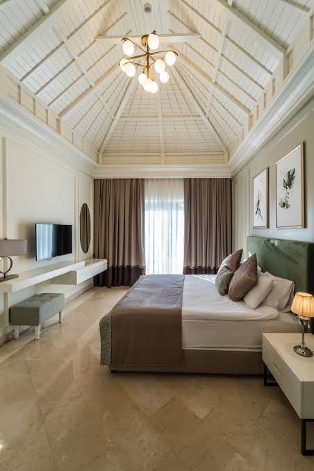 IC Hotels Green Palace elegants numurs ar augstiem koka griestiem, lielu gultu un modernu interjeru gaišos toņos