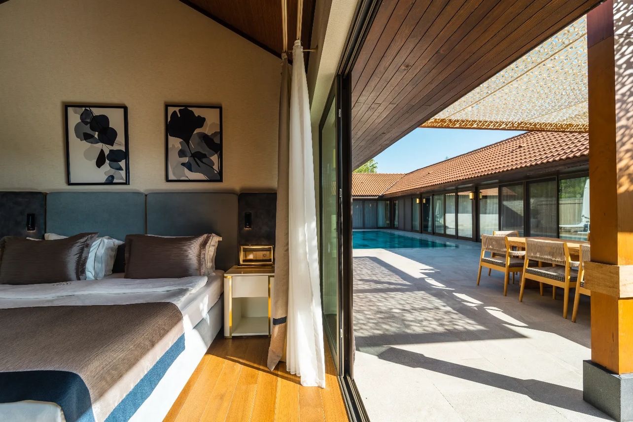 IC Hotels Green Palace luksusa numurs ar tiešu piekļuvi privātam baseinam un terasi — skats no guļamistabas uz saulaino āra zonu