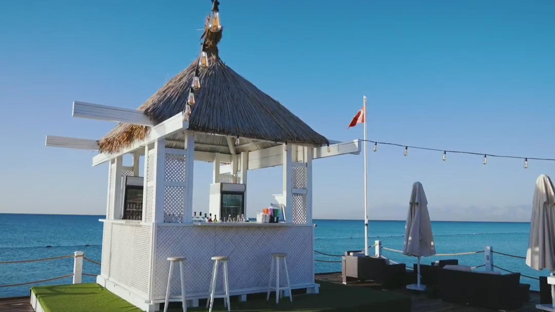 IC Hotels Green Palace pludmales bārs uz koka platformas ar salmu jumtu un skatu uz zilo Vidusjūru