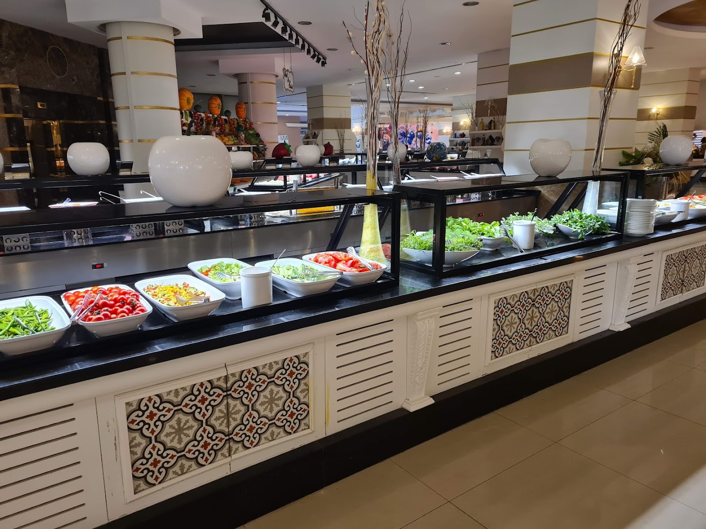 Crystal Prestige Elite galvenā restorāna bufetes zona ar plašu svaigu dārzeņu un salātu izvēli baltos traukos uz melnas virsmas