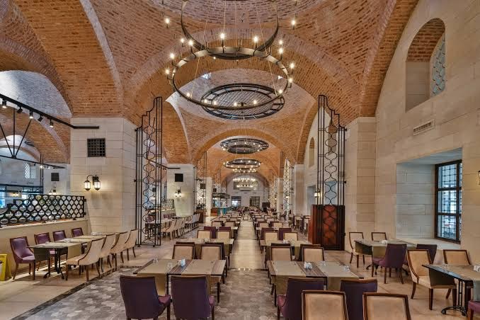 Swandor Hotels & Resorts Topkapi Palace galvenais restorāns ar vēsturiskām ķieģeļu velvēm un greznām lustrām Antalijā