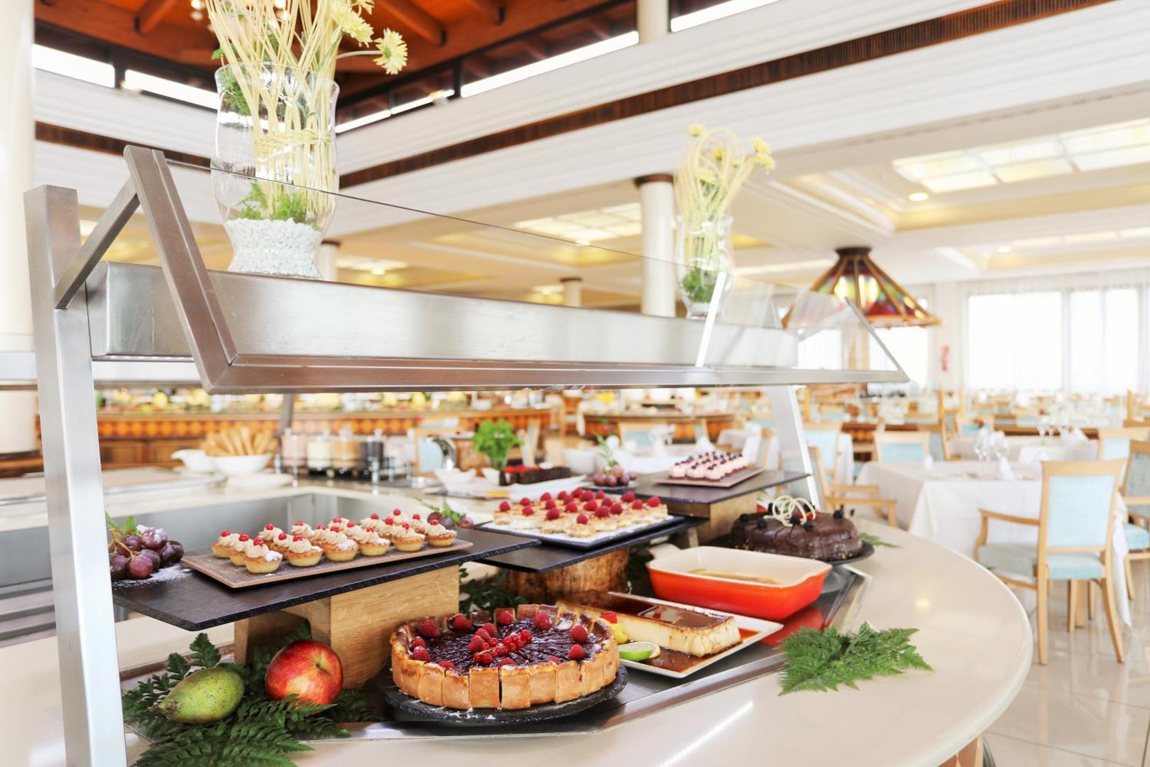 Iberostar Selection Anthelia bufetes restorāna desertu izvēle — kūkas ar ogām, groziņi un krēmi uz elegantiem stikla statīviem.