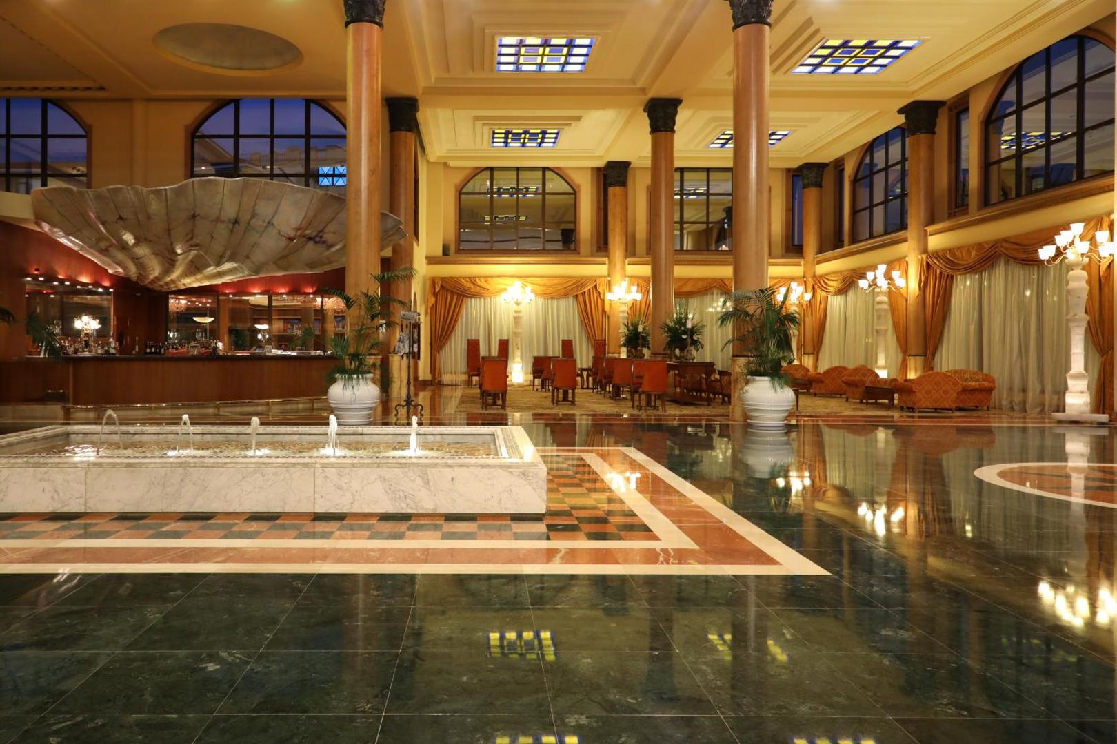 Iberostar Selection Anthelia viesnīcas greznais vestibils Tenerifē ar marmora grīdu, dekoratīvu strūklaku, augstām kolonnām un atpūtas zonu siltos toņos