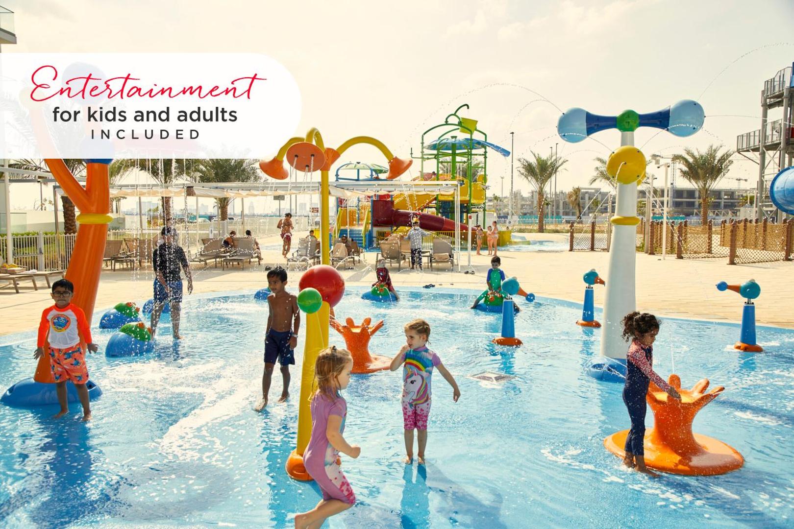 RIU Dubai bērnu ūdens rotaļu laukums ar strūklakām un seklu baseinu, kur bērni spēlējas saulainā dienā