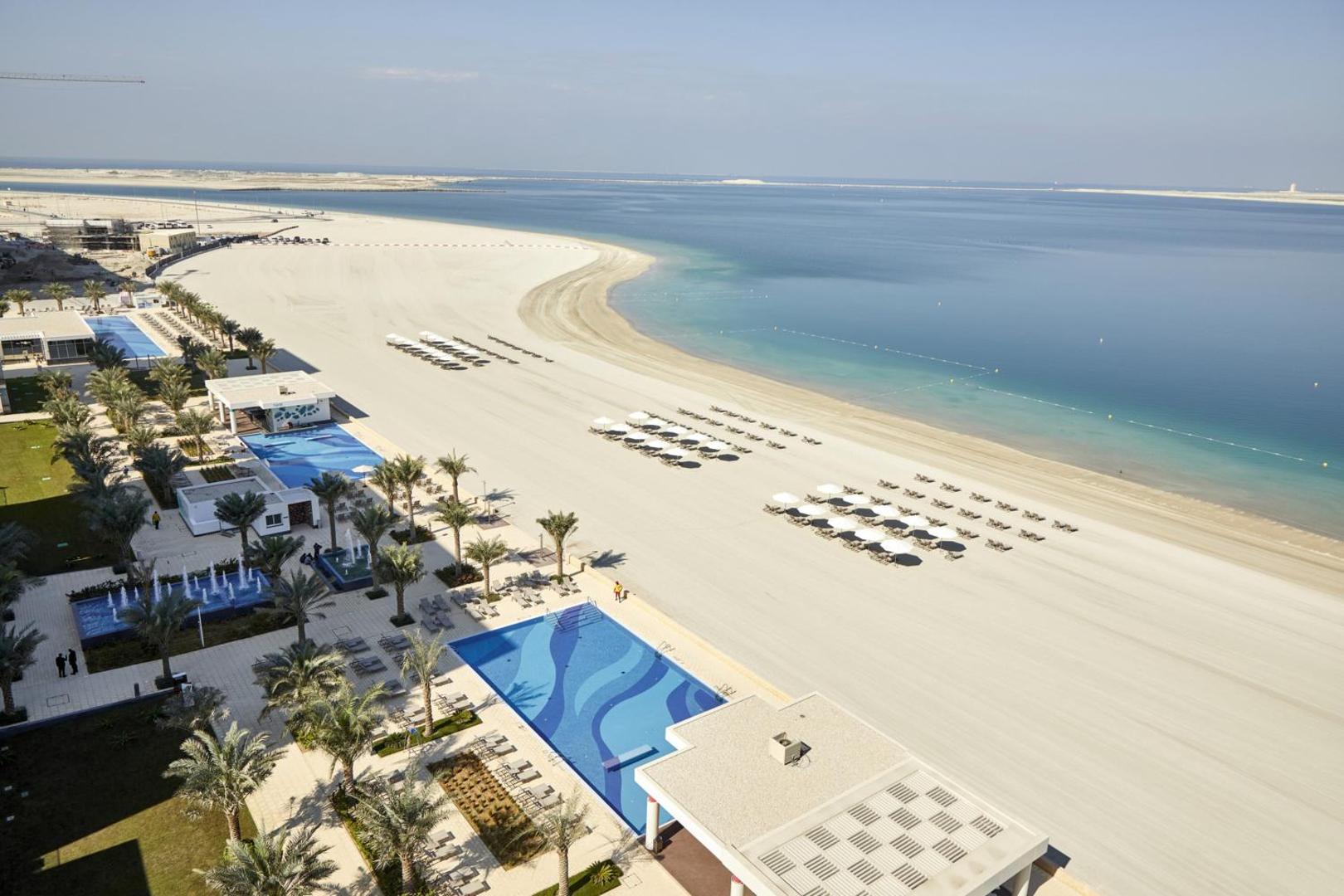 Skats no augšas uz RIU Dubai privāto pludmali, baseiniem un Persijas līča zilo ūdeni Deira Islands rajonā.