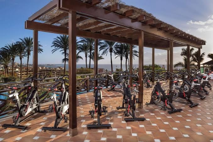Āra velotrenažieru zona zem nojumes Melia Jardines del Teide viesnīcā ar skatu uz palmām un okeānu