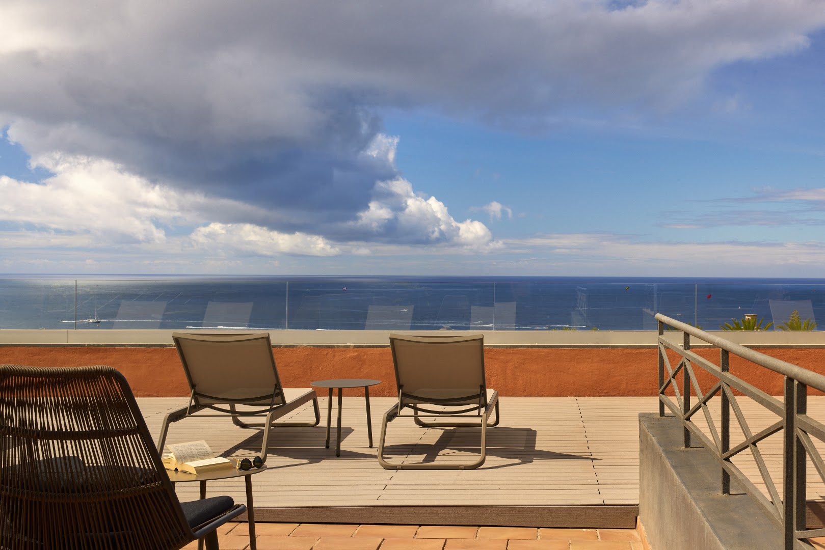 Melia Jardines del Teide sauļošanās terase ar diviem zviļņiem un stikla margām, no kuras paveras skats uz Atlantijas okeānu
