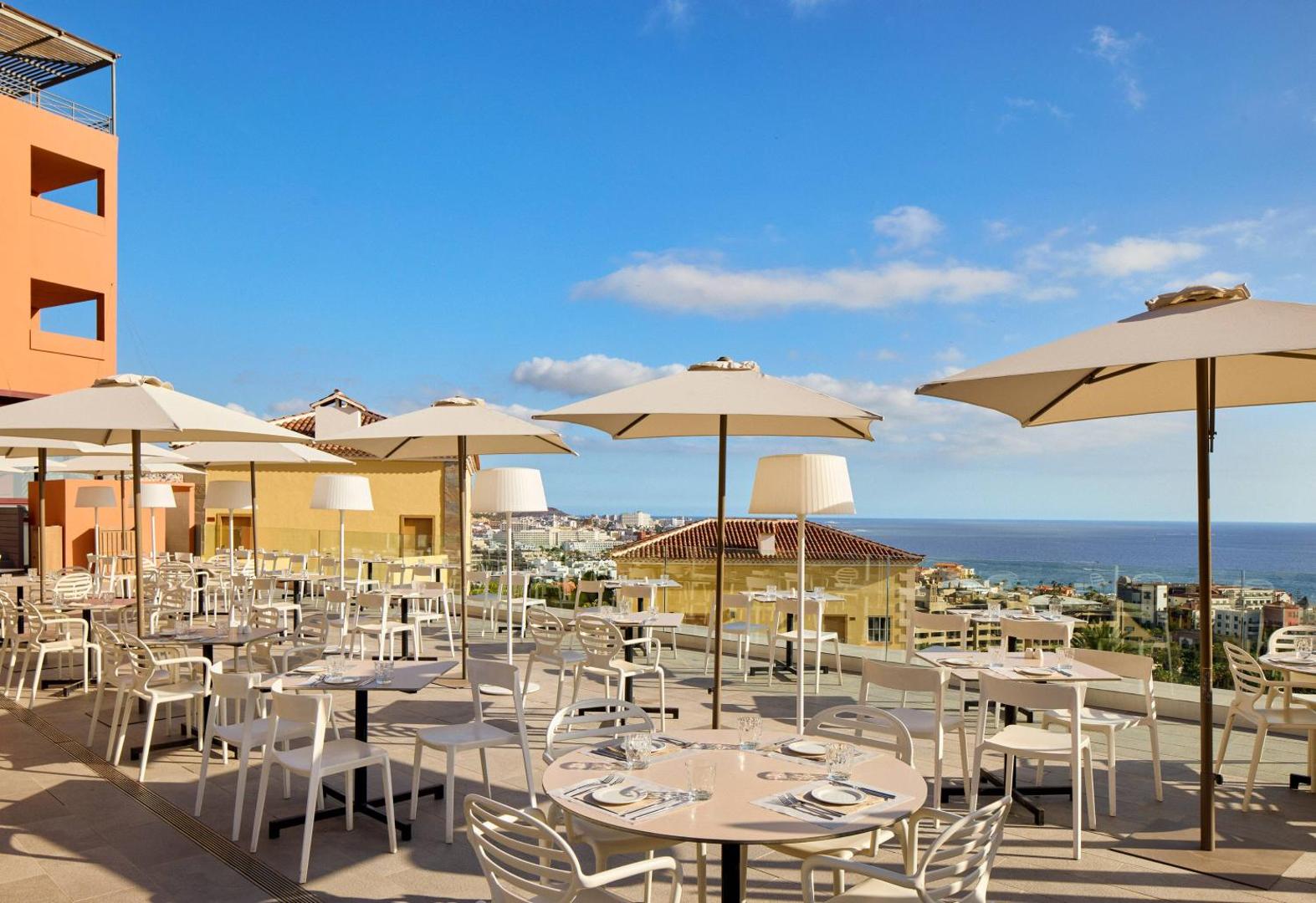 Meliá Jardines del Teide plaša brokastu terase ar saulessargiem un galdiņiem piekrastē, Tenerifē