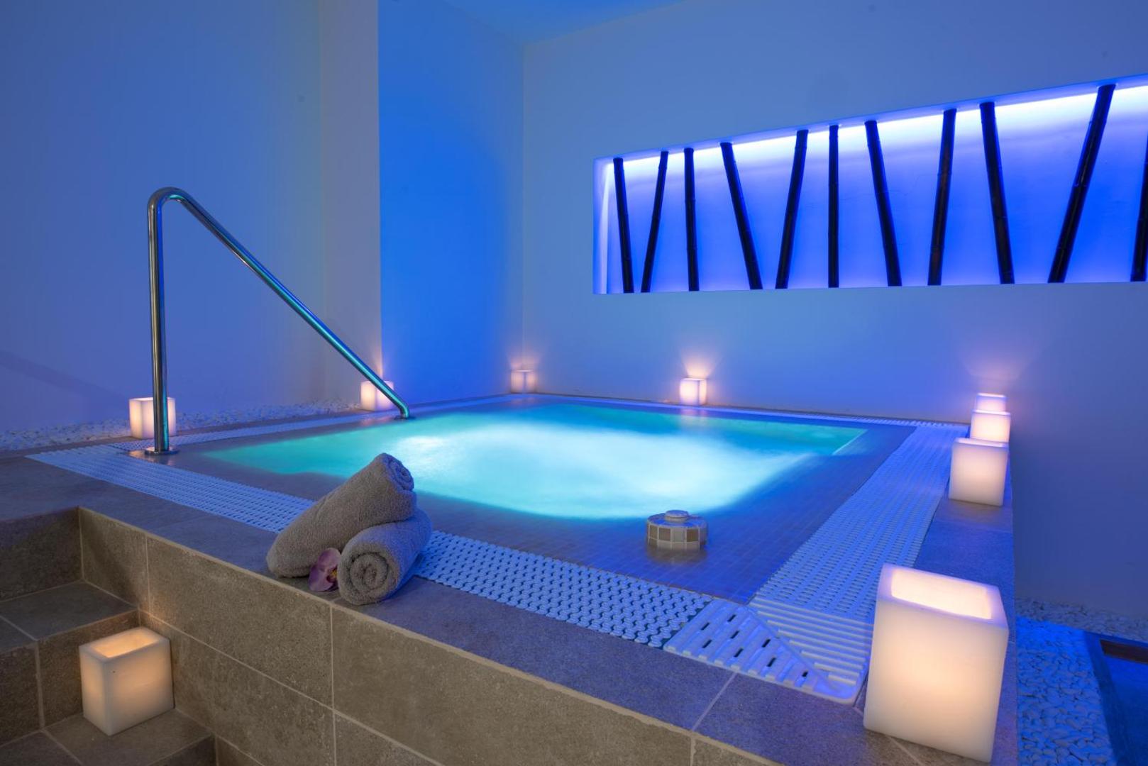 GF Isabel spa zonas iekštelpu džakuzi ar zilu apgaismojumu un svecēm — relaksējoša atmosfēra atpūtai Tenerifes kūrortā