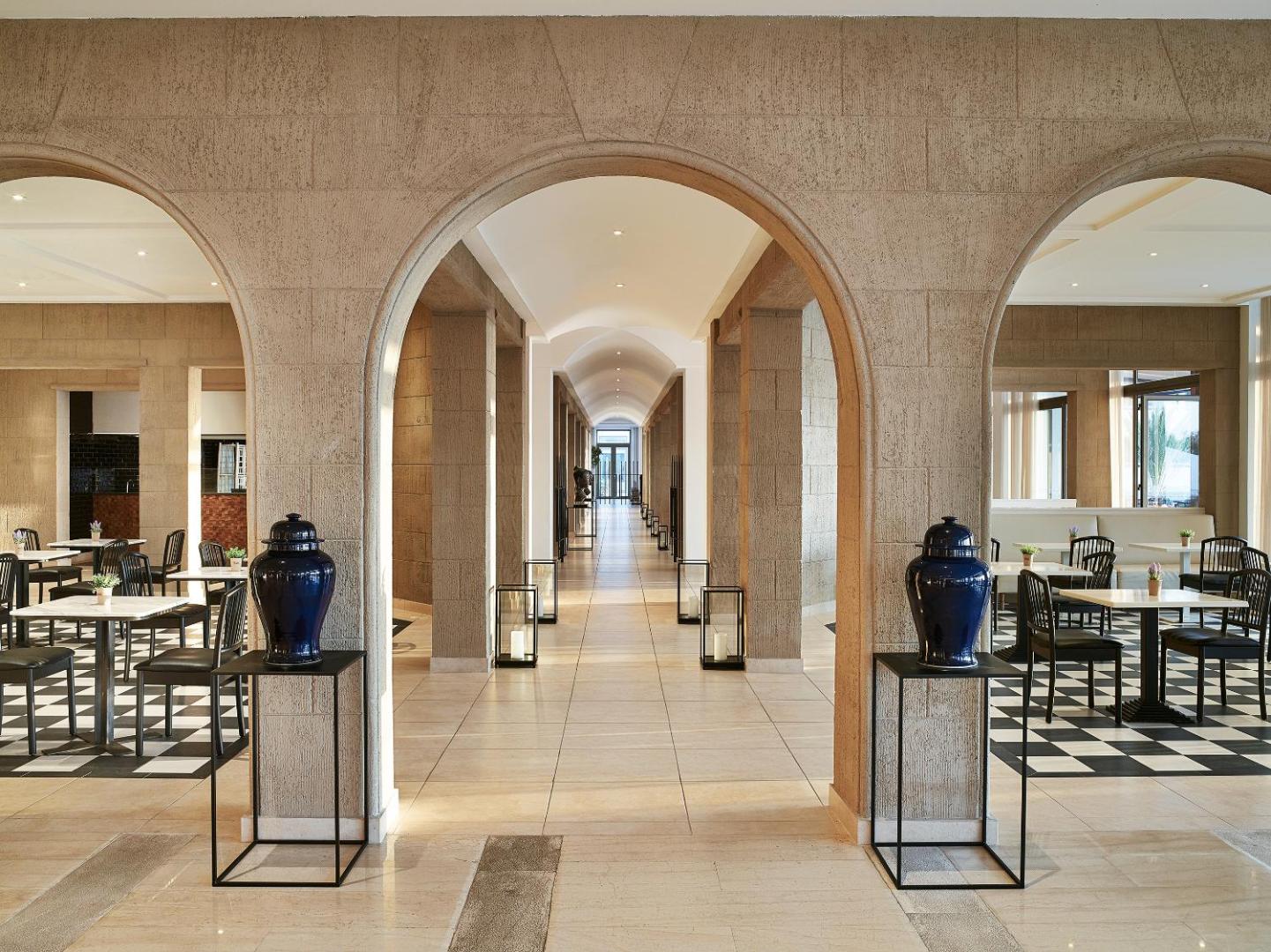 Grecotel Lux Me Dama Dama restorāna zona ar arkām, melnbaltām flīzēm un zilām vāzēm Rodas salas kūrortā