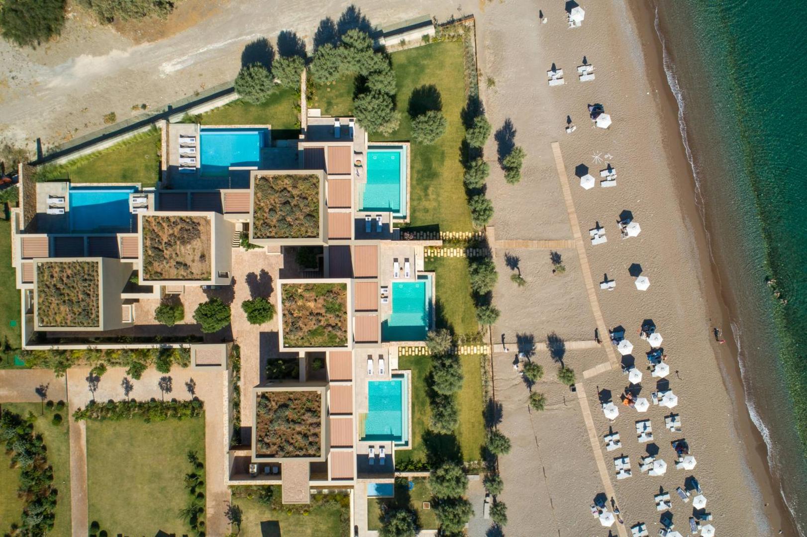 Amada Colossos Resort skats no augšas uz privātajiem baseiniem un smilšu pludmali ar saulessargiem Rodas salā