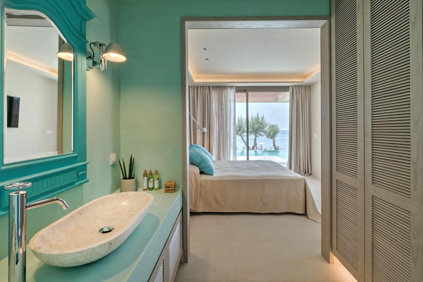 Amada Colossos Resort numura vannasistaba ar akmens izlietni un skatu uz guļamistabu un privāto baseinu piekrastē
