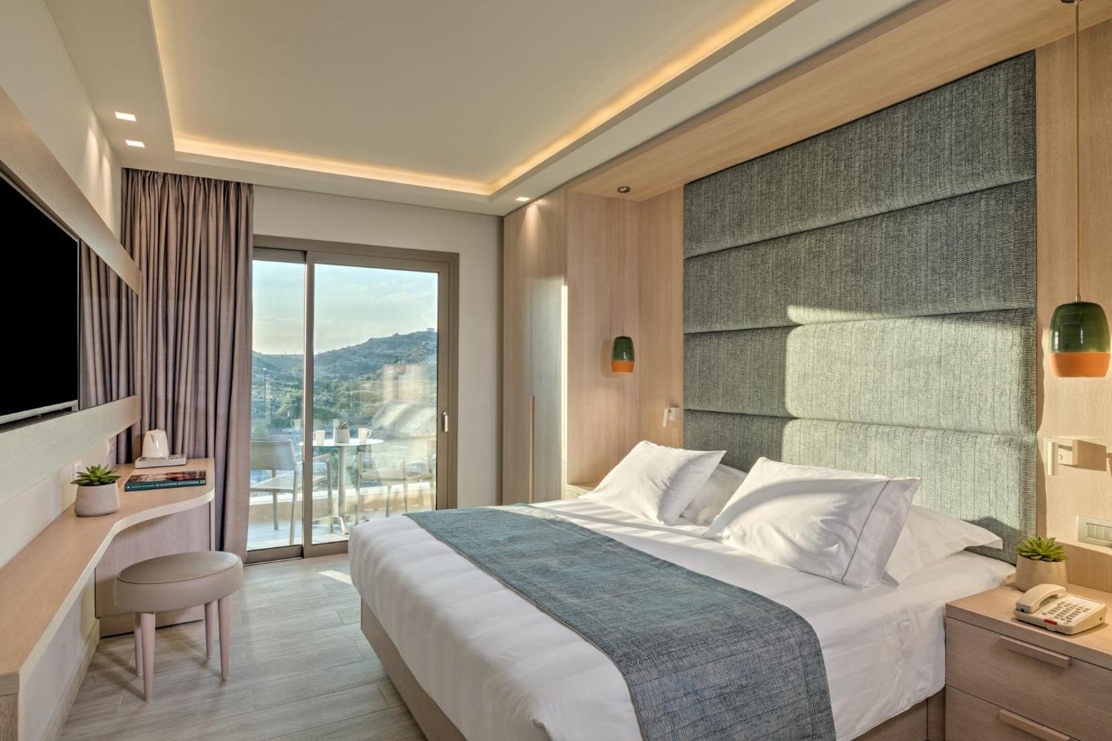 Amada Colossos Resort moderns divvietīgs numurs ar gaišu interjeru, balkonu un skatu uz kalniem