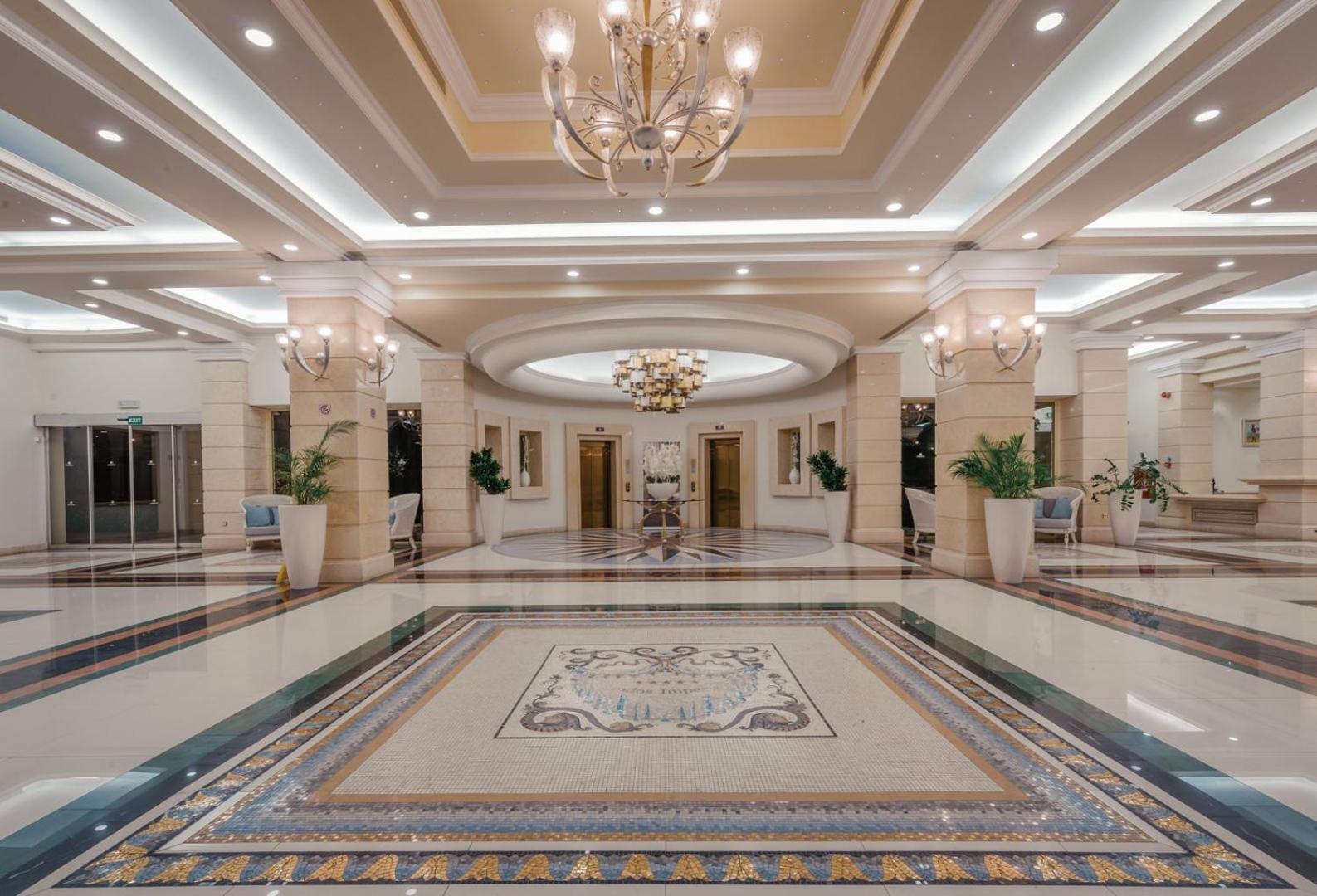 Lindos Imperial Resort & SPA greznais vestibils ar marmora grīdām, mozaīkām, augstiem griestiem un elegantām lustrām