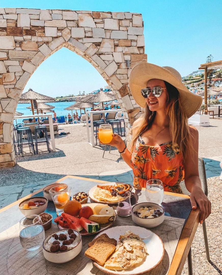 Viesnīcas Eden Roc Resort viesis bauda bagātīgas brokastis āra terasē Rodas salā ar skatu uz pludmali un jūru