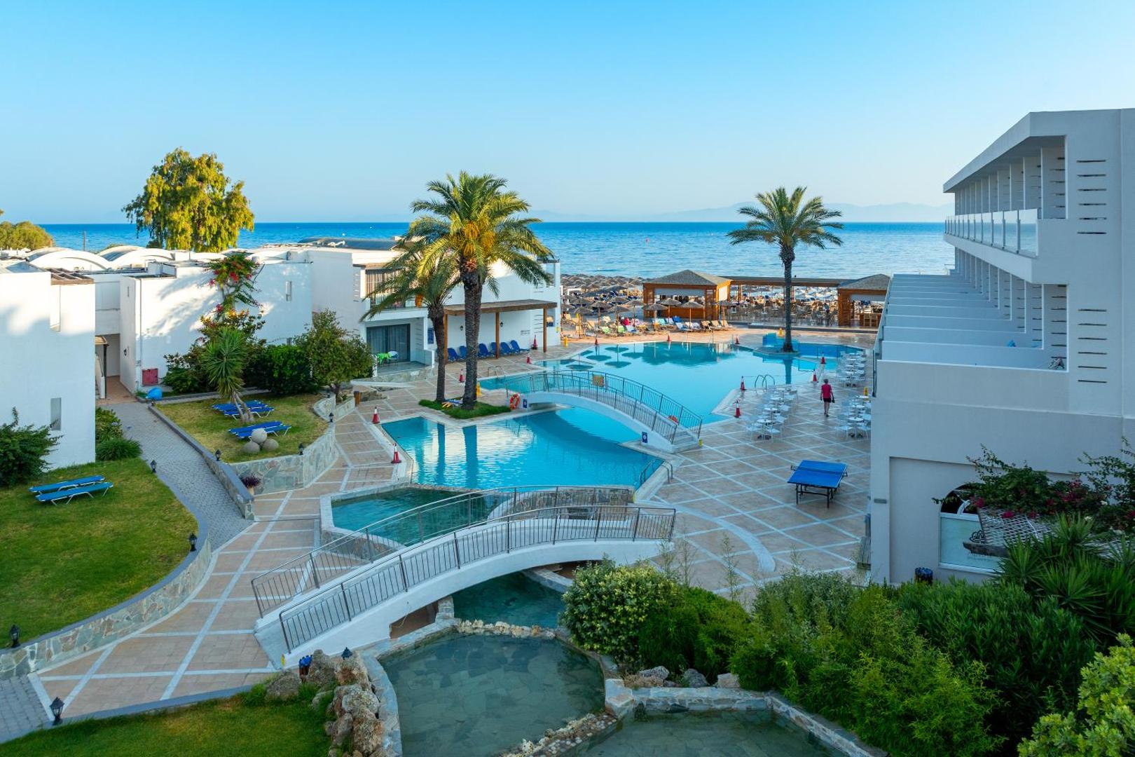 Avra Beach Resort Hotel & Bungalows skats no augšas uz baseinu kompleksu, tiltiņiem un Vidusjūras piekrasti Rodas salā, Grieķijā