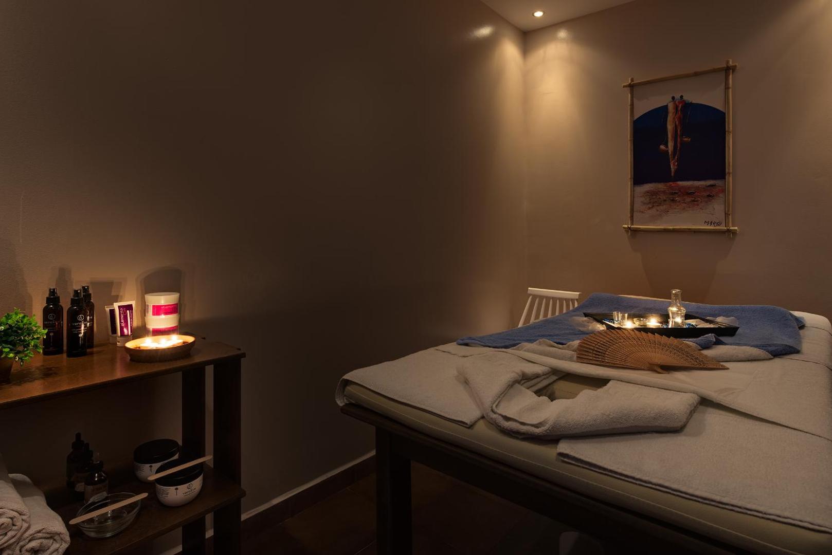 Avra Beach Resort spa procedūru telpa ar masāžas galdu, svecēm un relaksējošu apgaismojumu mierpilnai atpūtai Rodas salā