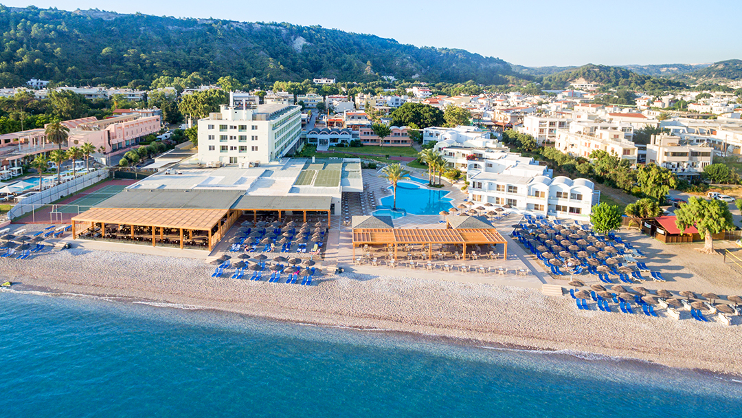 Avra Beach Resort panorāmas skats uz teritoriju, āra baseinu un pludmales zonu ar saulessargiem Rodas piekrastē saulainā dienā