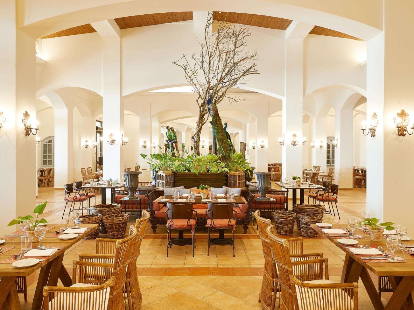 Grecotel LUXME Oasis at Riviera Olympia galvenais restorāns ar augstiem griestiem, arkām un elegantu interjera dekoru