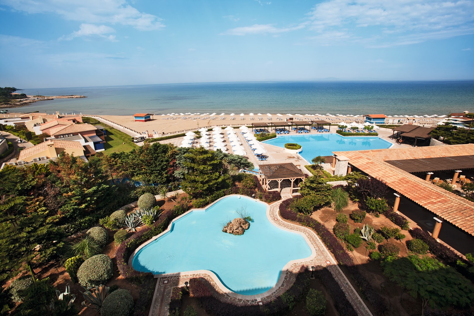 Aldemar Olympian Village kūrorta panorāmas skats uz baseiniem un plašo smilšu pludmali Peloponēsas piekrastē Grieķijā saulainā dienā