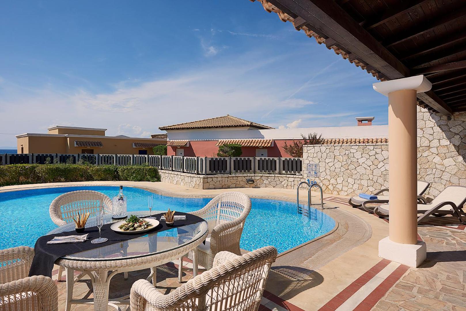 Aldemar Olympian Village numurs ar tiešu piekļuvi baseinam un privātu terasi, kur uzklāts galds brokastīm vai uzkodām brīvā dabā.