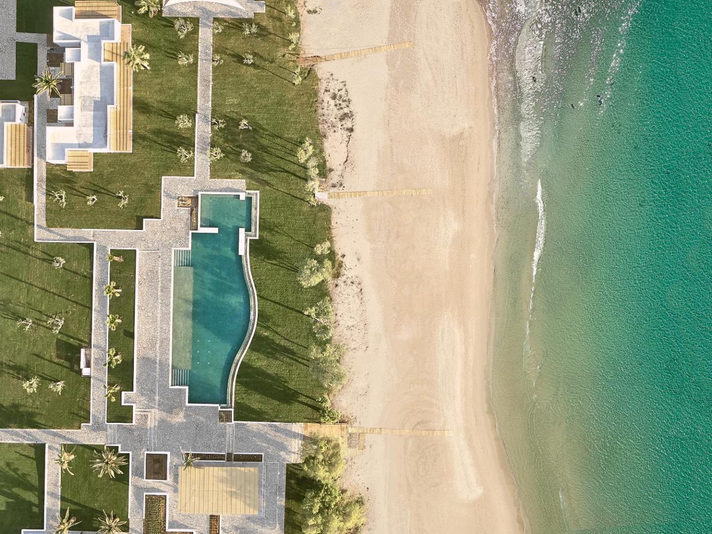 Grecotel Casa Marron viesnīcas teritorija pie pašas jūras — baseins, smilšu pludmale un tirkīzzils ūdens Peloponēsas reģionā