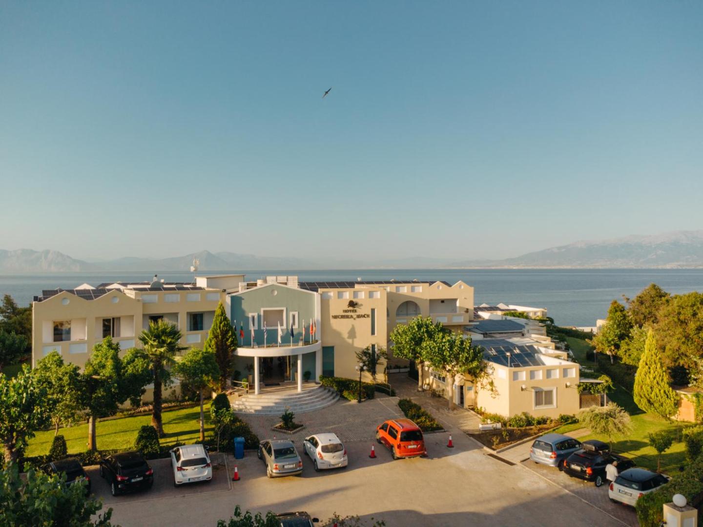 Niforeika Beach Hotel & Bungalows galvenā ieeja un fasāde Peloponēsā — skats uz jūru fonā un viesnīcas autostāvvietu